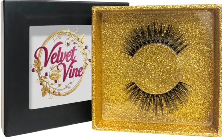 Velvet Vine false eyelashes in gold glitter packaging with black lashes displayed on the lid